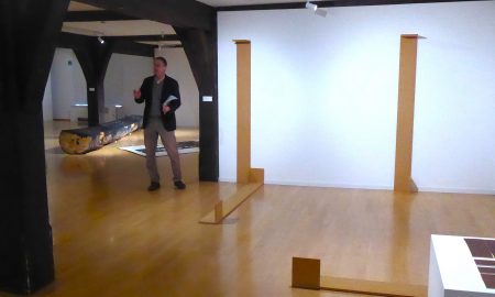 Kurator Rainer Lawicki bei der "Holz"-Ausstellung mit Werken von Chrisdtian Wulffen und Felix Droesens (flachgelegter) "Hölderlinsäule im Hintergrund. Foto: Martin Bernklau